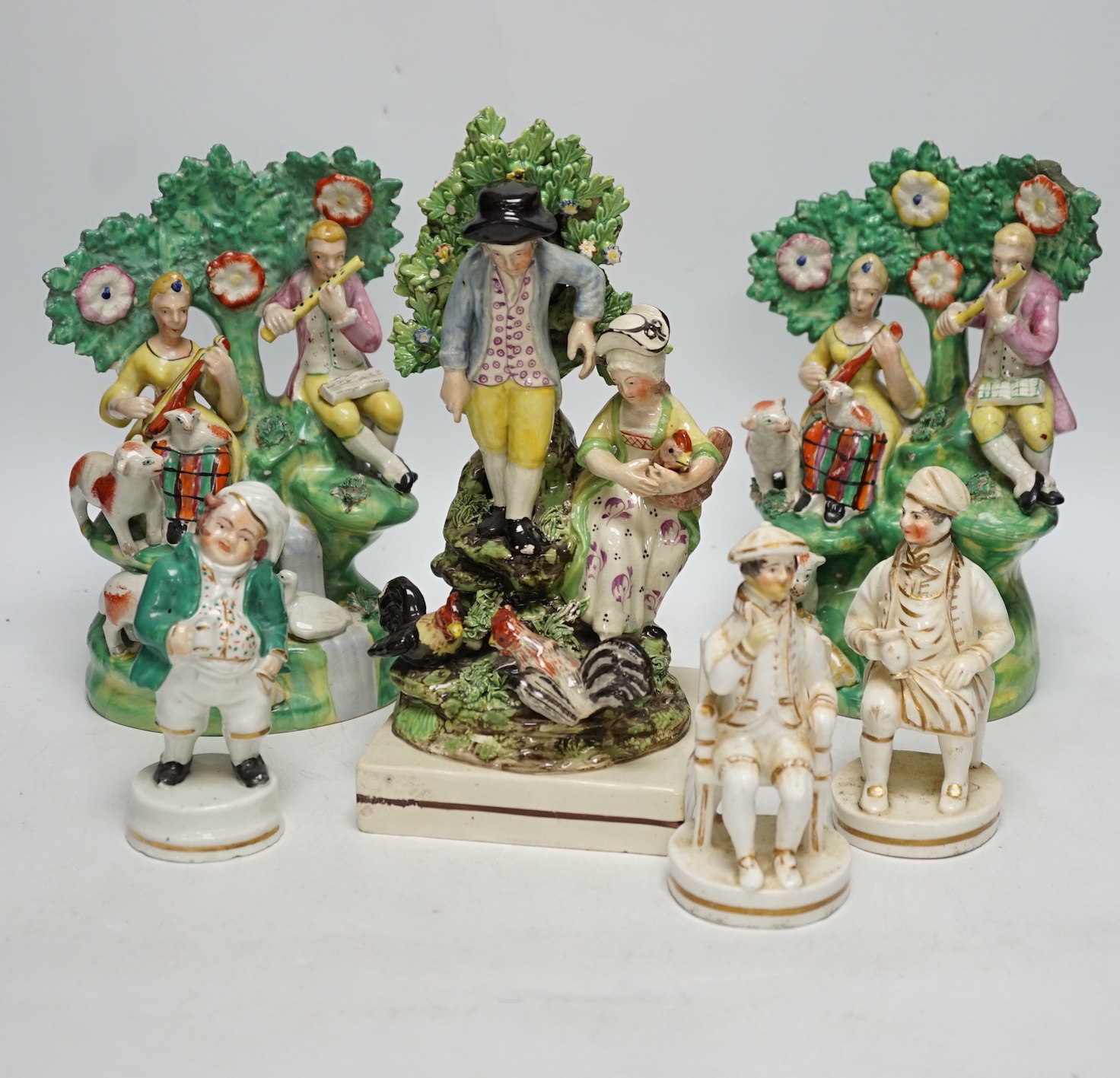 A Staffordshire pottery group of two figures with chickens, c.1800-10, a pair of early 20th century Staffordshire pottery figure groups and three small character figures, tallest 25cm high (6)